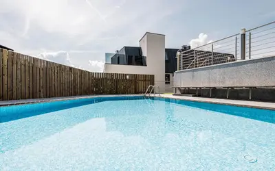 a large swimming pool on the side of a building at AMELIA rooms in Tirolo