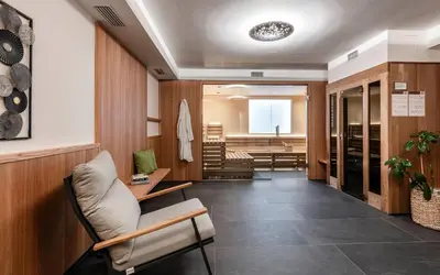 a waiting room with a chair and a table at AMELIA rooms in Tirolo