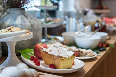 a table topped with plates of food and fruit at AMELIA apartments in Tirolo