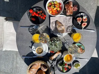 a table topped with plates of food and drinks at AMELIA apartments in Tirolo