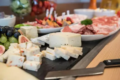 a tray of cheese and other foods on a table at AMELIA apartments in Tirolo