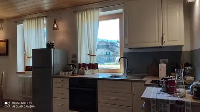 a kitchen with a refrigerator and a window at Mini Maule in Cavalese