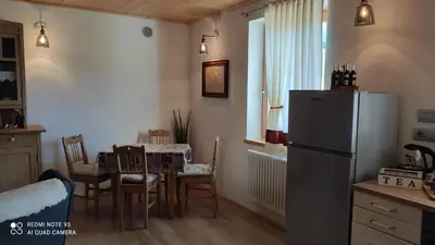 a kitchen with a refrigerator and a table with chairs at Mini Maule in Cavalese
