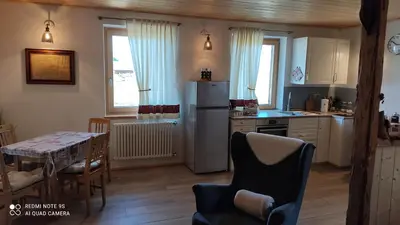 a kitchen with a refrigerator and a table and chairs at Mini Maule in Cavalese