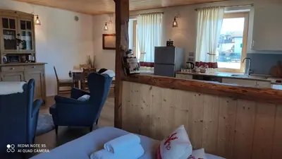 a kitchen and living room with a table and chairs at Mini Maule in Cavalese