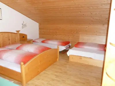 two beds in a room with wooden walls at Residence Alpenblick in Valles