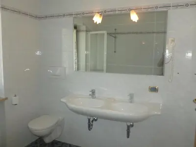 a bathroom with a sink and a toilet and a mirror at Residence Alpenblick in Valles
