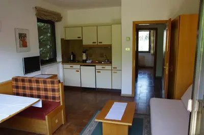 a kitchen with white cabinets and a table at Appartements Oberpefohl in Parcines