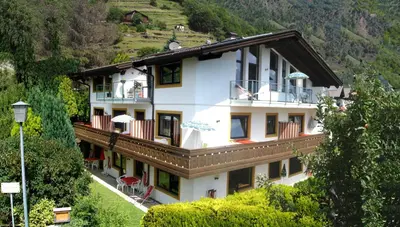 a large white building with balconies on a mountain at Appartements Oberpefohl in Parcines