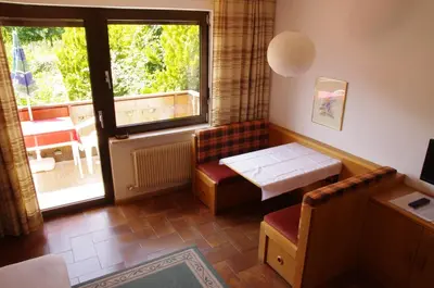 a living room with a table and a window at Appartements Oberpefohl in Parcines