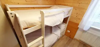 a small room with a bunk bed in a cabin at Appartamento Pampeago 10 in Tesero