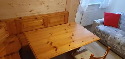 a wooden table in a room with a couch at Appartamento Pampeago 10 in Tesero
