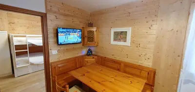 a room with a tv in a wooden wall at Appartamento Pampeago 10 in Tesero