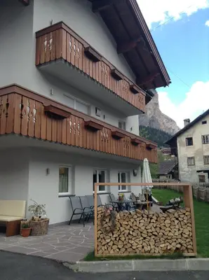 a building with a balcony and a table and chairs at Villa Seceda in Selva di Val Gardena