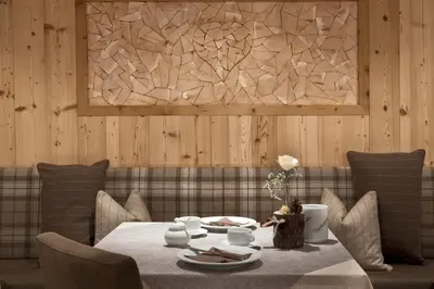 a dining room with a table and a couch at Hotel Comploj Adults only in Selva di Val Gardena
