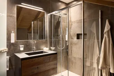 a bathroom with a glass shower and a sink at Hotel Comploj Adults only in Selva di Val Gardena