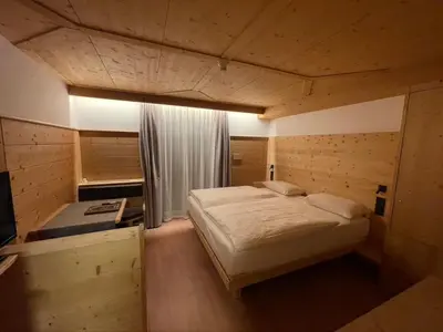 a bedroom with a large bed in a room at Hotel Des Alpes in Selva di Val Gardena