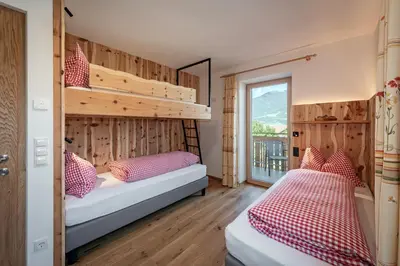 a bedroom with two beds and a balcony at Hörmannhof in Bressanone