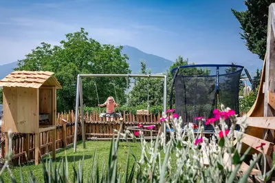 a little girl on a swing in a playground at Hörmannhof in Bressanone