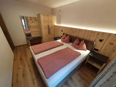 a bedroom with two beds in a room with wooden floors at Hörmannhof in Bressanone