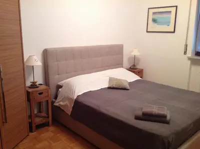 a bedroom with a bed and two night stands with lamps at HOME DI CRISTINA in Laives