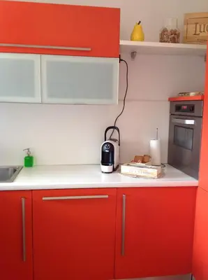 a kitchen with red cabinets and a toaster on the counter at HOME DI CRISTINA in Laives