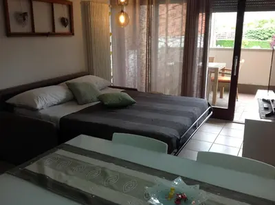 a living room with a bed and a table and a couch at HOME DI CRISTINA in Laives