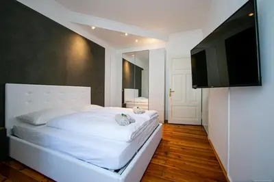 a bedroom with a white bed and a flat screen tv at Apartment Andreas in Bolzano