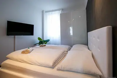 a bed with two pillows and a television in a room at Apartment Andreas in Bolzano