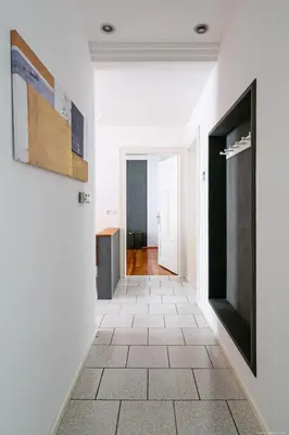 a hallway with white walls and a tile floor at Apartment Andreas in Bolzano