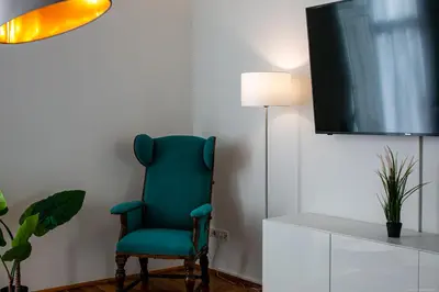 a green chair in a room with a tv at Apartment Andreas in Bolzano