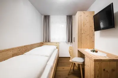 a room with a bed and a desk and a tv at Chalet Dolomit in San Lorenzo di Sebato