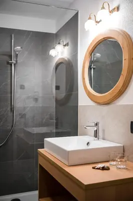 a bathroom with a sink and a shower and a mirror at Chalet Dolomit in San Lorenzo di Sebato