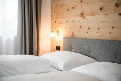 two beds with white pillows in a hotel room at Chalet Dolomit in San Lorenzo di Sebato