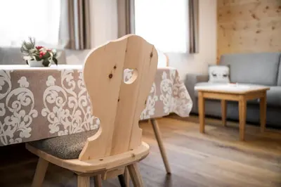 a wooden chair sitting in a living room at Chalet Dolomit in San Lorenzo di Sebato