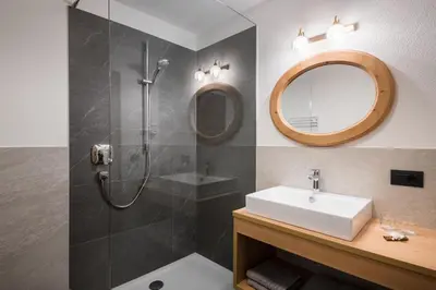 a bathroom with a shower and a sink and a mirror at Chalet Dolomit in San Lorenzo di Sebato
