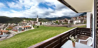 a balcony with a table and a view of a town at Apartments Sayonara in Castelrotto