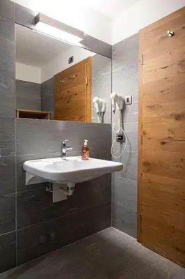 a bathroom with a sink and a mirror at Albergo Belvedere in Vigo di Fassa