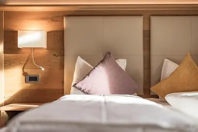 a bedroom with a bed with pillows on it at Albergo Belvedere in Vigo di Fassa