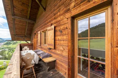 a bedroom in a log cabin with a window at Villa al Bosco in Selva di Val Gardena