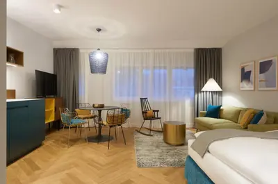 a hotel room with a bed and a living room at Cityflair Boutique Apartments in Bolzano