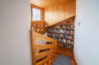 a small room with a book shelf and a staircase at Oberkapillhof in Meltina