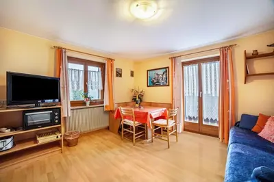 a living room with a table and a blue couch at Oberkapillhof in Meltina