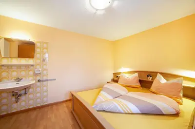 a small bedroom with a bed and a sink at Oberkapillhof in Meltina