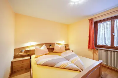 a bedroom with a bed and a desk and a window at Oberkapillhof in Meltina