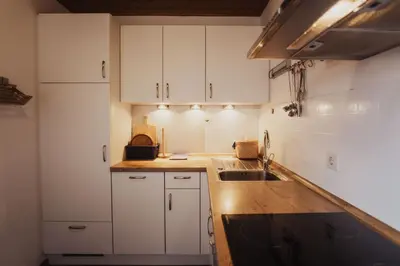 a kitchen with white cabinets and a sink at Töllhof Apartments and Farm in Naz-Sciaves