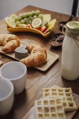a wooden table with bread and fruit and a plate of food at Töllhof Apartments and Farm in Naz-Sciaves