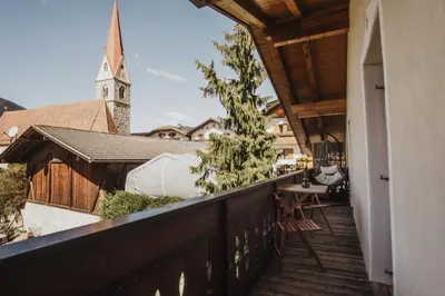 a balcony with a view of a church at Töllhof Apartments and Farm in Naz-Sciaves
