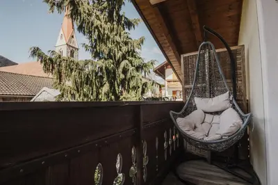 a swing on a balcony with a christmas tree at Töllhof Apartments and Farm in Naz-Sciaves