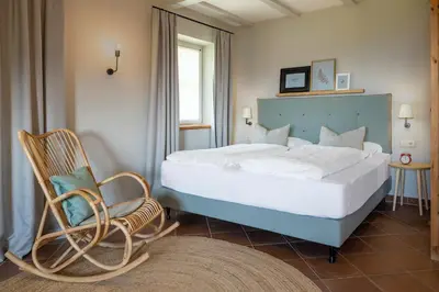 a bedroom with a large bed and a chair at Villa Gloria in Soprabolzano